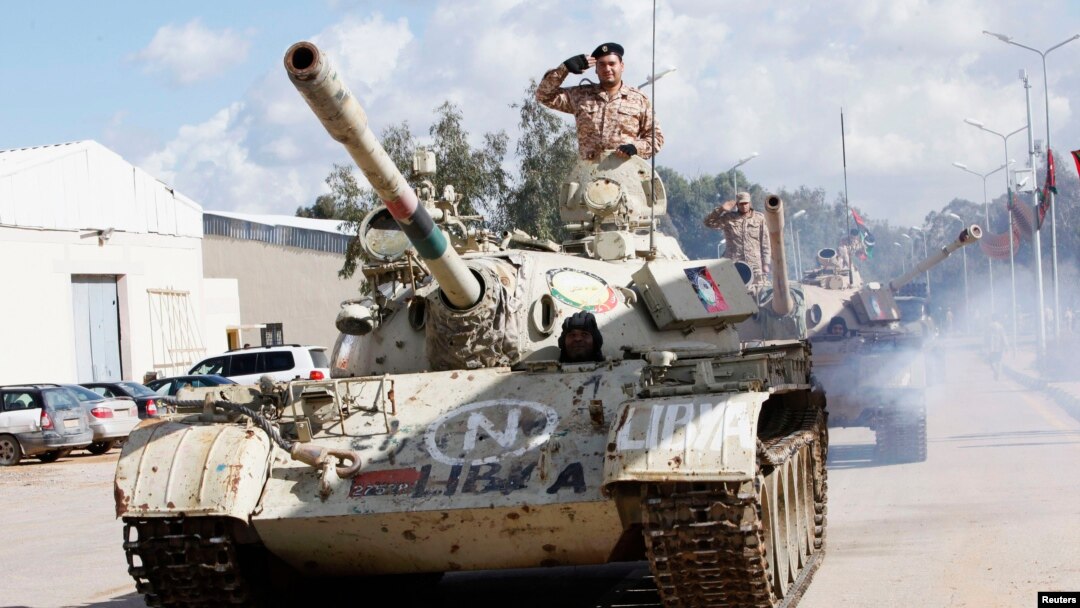 Seorang tentara memberi hormat sambil berdiri di dalam tank saat parade upacara wisuda perwira angkatan darat Libya di Tripoli (16/1). 