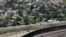FILE - A residential neighborhood of Juarez, Mexico, and U.S. Border Patrol vehicles on both sides of a border fence as seen from El Paso Texas, on April 22, 2020. 