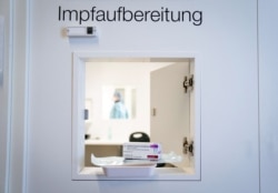 FILE - A syringe and a pack of the Oxford–AstraZeneca COVID-19 vaccine are seen on the opened window of a pass-through at the newly opened vaccination center, in the former Berlin Tegel Airport, in Berlin, Feb. 10, 2021.