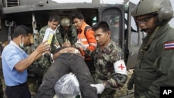 An injured Thai soldier on a stretcher is helped to board a helicopter to be transferred to a hospital following the clashes between Thailand and Cambodia in Surin province, northeastern Thailand, April 28, 2011.