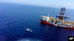 In this Tuesday, July 9, 2019 photo, a helicopter flies near Turkey's drilling ship, 'Fatih' dispatched towards the eastern Mediterranean, near Cyprus. 