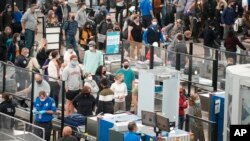 Varias filas de viajeros frente a los puestos de control de seguridad en el Aeropuerto Internacional de Denver, el 23 de noviembre de 2021, antes del feriado del Día de Acción de Gracias. 