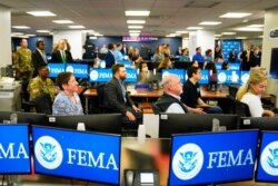 FEMA employees listen to President Joe Biden talk at FEMA headquarters, in Washington, May 24, 2021.