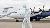 A member of a medical team wearing a protective suit cleans the airfield to prevent the spread of COVID-19 at the Juba International Airport in Juba, South Sudan, on April 5, 2020.