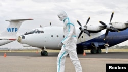 A member of a medical team wearing a protective suit cleans the airfield to prevent the spread of COVID-19 at the Juba International Airport in Juba, South Sudan, on April 5, 2020.