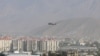 FILE - A NATO helicopter flies over the city of Kabul, Afghanistan.