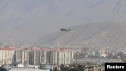 FILE - A NATO helicopter flies over the city of Kabul, Afghanistan.