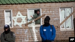 A settler looks out the window in the West Bank outpost Amona, Feb. 1, 2017. Israeli forces have begun evacuating the controversial settlement, which is the largest of about 100 unauthorized outposts erected in the West Bank without permission but generally tolerated by the Israeli government.