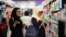 FILE - Malaysian women chat as they shop at a mall in Petaling Jaya outside Kuala Lumpur, Malaysia, Oct. 30, 2014.