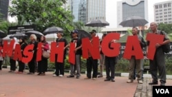 Komisi untuk Orang Hilang dan Korban Tindak Kekerasan (Kontras) bersama korban pelanggaran HAM berat masa lalu melakukan aksi di depan Kantor Kementerian Koordinator Politik Hukum dan Keamanan, Jakarta Kamis 31/3 (VOA/Fathiyah).