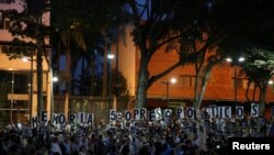 FILE - People hold placards at a rally to pay tribute to victims of violence in protests against Venezuelan President Nicolas Maduro's government, in Caracas, Venezuela, Aug. 30, 2017.