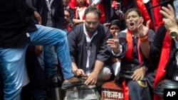 FILE - An Indian Youth Congress member polishes a shoe to symbolize unemployment as he joins a protest where they marked Indian Prime Minister Narendra Modi's birthday as National Unemployment Day in Mumbai, Sept. 17, 2021. 