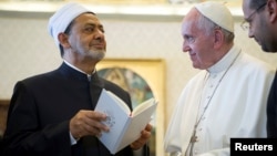 FILE - Pope Francis exchanges gifts with Sheikh Ahmed Mohamed el-Tayeb, left, Egyptian Imam of al-Azhar Mosque at the Vatican, May 23, 2016.