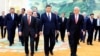 In this photo released by Xinhua News Agency, Chinese President Xi Jinping, center, walks with representatives from U.S. business, strategic and academic concerns at the Great Hall of the People in Beijing, March 27, 2024.