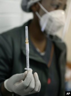 FILE - A medical staff member prepares a syringe at the Chris Hani Baragwanath hospital in Soweto, Johannesburg, June 24, 2020.