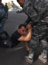 Armenian police officers detain a protester during a rally against land transfer to Azerbaijan, in Yerevan on April 27, 2024.