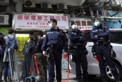 Police officers stand guard outside office of District councilor and lawyer Daniel Wong Kwok-tung in Hong Kong, Jan. 14, 2021.