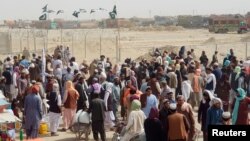 People gather and wait to welcome their relatives arriving from Afghanistan, at the Friendship Gate crossing point at the Pakistan-Afghanistan border town of Chaman, Pakistan, Aug. 17, 2021.