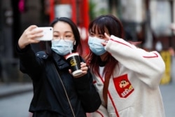 People take a selfie as Chinatown prepares for Chinese Lunar New Year, in London, Feb. 11, 2021.