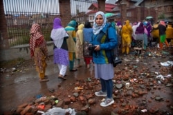 FILE - Kashmiri photojournalist Masrat Zahra stands for a photograph during a protest on the outskirts of Srinagar, Indian controlled Kashmir, October 4, 2019.