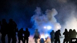 Authorities fire gas munitions at demonstrators gathered outside the Brooklyn Center Police Department to protest the shooting death of Daunte Wright, late April 13, 2021, in Brooklyn Center, Minn. 