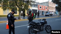 Un policía revisa el permiso de circular de un ciudadano durante la pandemia de COVID-19 en la Ciudad de Guatemala.