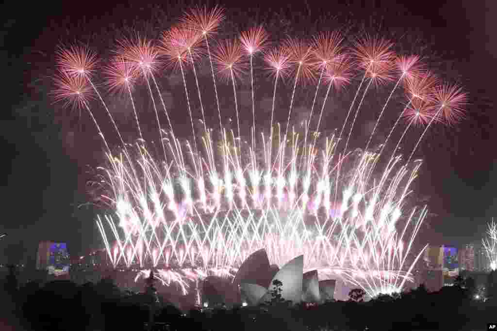 Los fuegos artificiales estallan sobre la ópera de Sydney en Australia, además del puente del puerto, mientras que las celebraciones del Año Nuevo están en curso. (Foto AP)