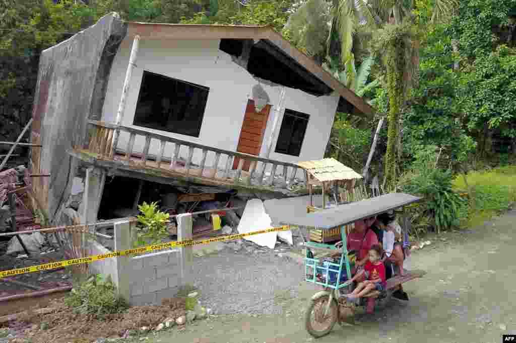 A motorist drives past a destroyed house after a large earthquake that hit Surigao City, in southern island of Mindanao, Philippines. Fifty-one people were injured and several homes, churches and other buildings damaged&nbsp; when an earthquake sent terrified residents of the southern Philippines fleeing their homes before dawn, police said.