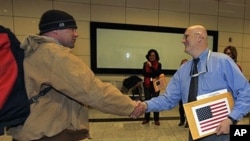 An American evacuee from Libya is welcomed by a U.S. embassy official, right, after his arrival at the Ataturk Airport in Istanbul, Turkey, February 25, 2011