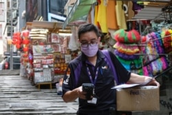 A FedEx courier with a protective mask brings a delivery, following the novel coronavirus disease (COVID-19) outbreak, in Hong Kong, China, March 27, 2020.
