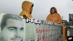 Supporters stand in the rain with a sign outside of US District Court in Boston, October 27, 2011, during the first day in the trial of Tarek Mehanna, 29, of Sudbury, Massachusetts, who is charged with providing support to a terrorist group.