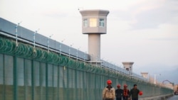 CHINA – Workers walk by the perimeter fence of what is officially known as an education centre in Dabancheng, on September 4, 2018.