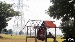 ຫຼັກເສົາສົ່ງກະແສໄຟຟ້າຂະໜາດໃຫຍ່ ເຫັນໄດ້ຢູ່ທົ່ງນາແຫ່ງນຶ່ງໃນລາວ.