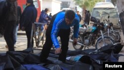 Một người đàn ông cố gắng xác định các thi thể sau những gì các nhà hoạt động cho biết là cuộc không kích được thực hiện bởi các lực lượng không quân Nga tại thành phố Idlib, Syria, ngày 20/12/2015.