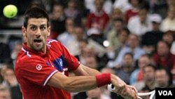 Novak Djokovic mengembalikan bola lawannya, petenis Perancis Gilles Simon, dalam Piala Davis yang saat ini imbang 1-1.