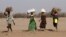 FILE - Women carry firewood on their heads outside the Kakuma refugee camp in Turkana county, northwest of Nairobi, Kenya, Feb. 1, 2018. 