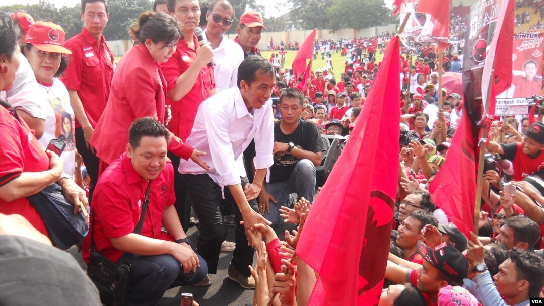 Calon Presiden dari PDI Perjuangan Jokowi bersalaman dengan para ribuan simpatisan dan kader PDI Perjuangan yang menghadiri kampanye terbuka Minggu 16 Maret 2014 di Gelanggang Olah Raga Cendrawasih Cengkareng Jakarta. (VOA/Andylala Waluyo)
