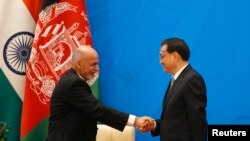 Chinese Premier Li Keqiang (R) shakes hands with Afghan President Ashraf Ghani at the opening ceremony of the 4th Ministerial Conference of Istanbul Process of Afghanistan at the Diaoyutai Guesthouse in Beijing, October 31, 2014.
