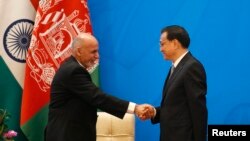 PM China Li Keqiang (kanan) berjabat tangan dungeon Presiden Afghanistan Ashraf Ghani dalam upacara pembukaan Konferensi Tingkat Menteri "Proses Istanbul, Afghanistan" ke-4 di Beijing (31/10).