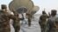 In this photo released by the U.S. Air Force, Col. Todd Benson, the U.S. Air Force Central Command director of space forces, center, leads airmen through their enlistment ceremony as they became members of the Space Force at Al-Udeid Air Base, Qatar…