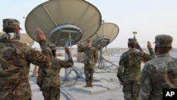 The U.S. Air Force Central Command director of space forces, center, leads airmen through their enlistment ceremony as they became members of the Space Force at Al-Udeid Air Base, Qatar, Sept. 1, 2020.