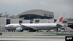 FILE - An Air China plane is parked at a gate at Los Angeles International Airport, in Los Angeles, California, May 9, 2019.