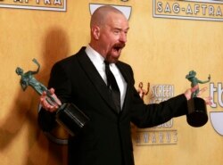 FILE - Actor Bryan Cranston poses with his awards for outstanding male actor in a drama series for 'Breaking Bad' and for outstanding cast in a motion picture for 'Argo' at the 19th annual Screen Actors Guild Awards in Los Angeles in 2019.