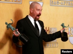 FILE - Actor Bryan Cranston poses with his awards for outstanding male actor in a drama series for 'Breaking Bad' and for outstanding cast in a motion picture for 'Argo' at the 19th annual Screen Actors Guild Awards in Los Angeles in 2019.