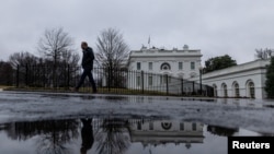 A reporter leaves the White House after the daily briefing, in Washington, Jan. 31, 2025.