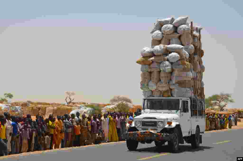 Carro sobrecarregado passa pelo campo de refugiados de Assaga na fronteira entre o Níger e a Nigéria.