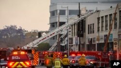 Los Angeles Fire Department firefighters work the scene of a structure fire that injured multiple firefighters on May 16, 2020, in Los Angeles. 