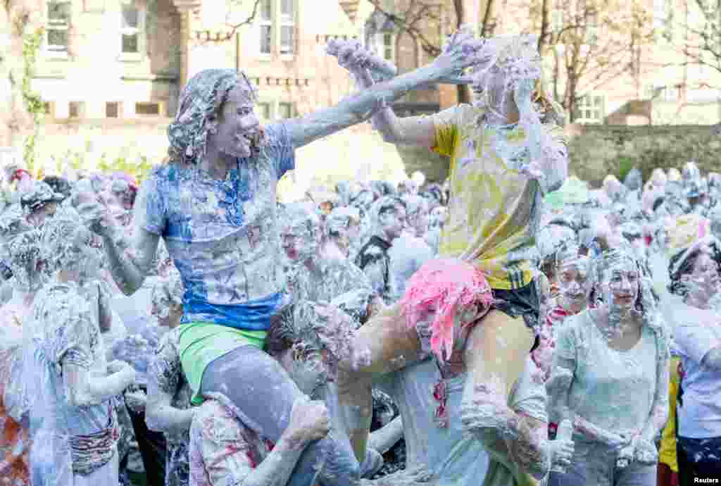 Para mahasiswa Universitas St. Andrews diselimuti busa setelah mengikuti acara tradisional &quot;Raisin Weekend&quot; di lapangan utama kampus di kota St. Andrews, Skotlandia, Inggris. (Reuters)&nbsp;