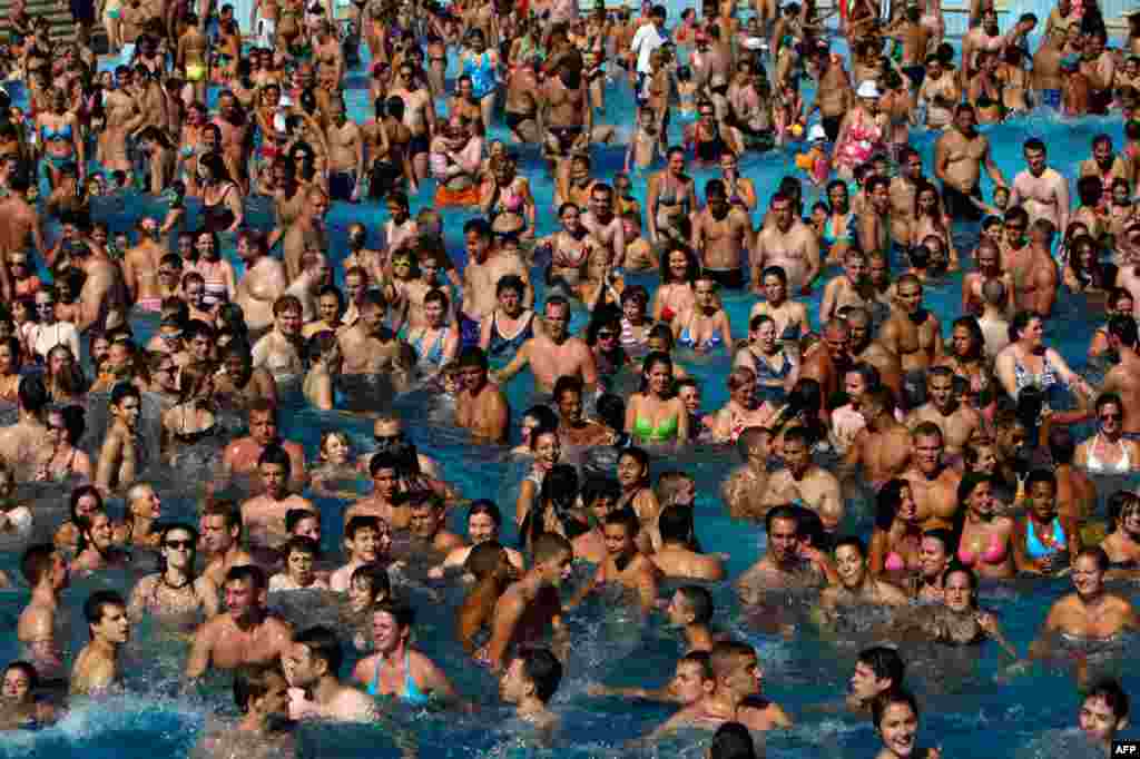 August 24: Folks cool off at a pool in the Palatinus outdoor spa in Budapest. Temperatures reached 38 degrees Celsius (100 degrees Fahrenheit) in Hungary. REUTERS/Bernadett Szabo