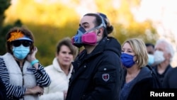 Para pemilih yang memakai masker wajah karena wabah Covid-19 menunggu antrean hampir empat jam untuk memberikan suara mereka selama pemungutan suara awal di AS, 29 Oktober 2020. (Foto: REUTERS/Nick Oxford)